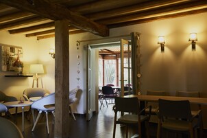 Un comedor con una mesa y sillas de madera, una lámpara y un aplique.