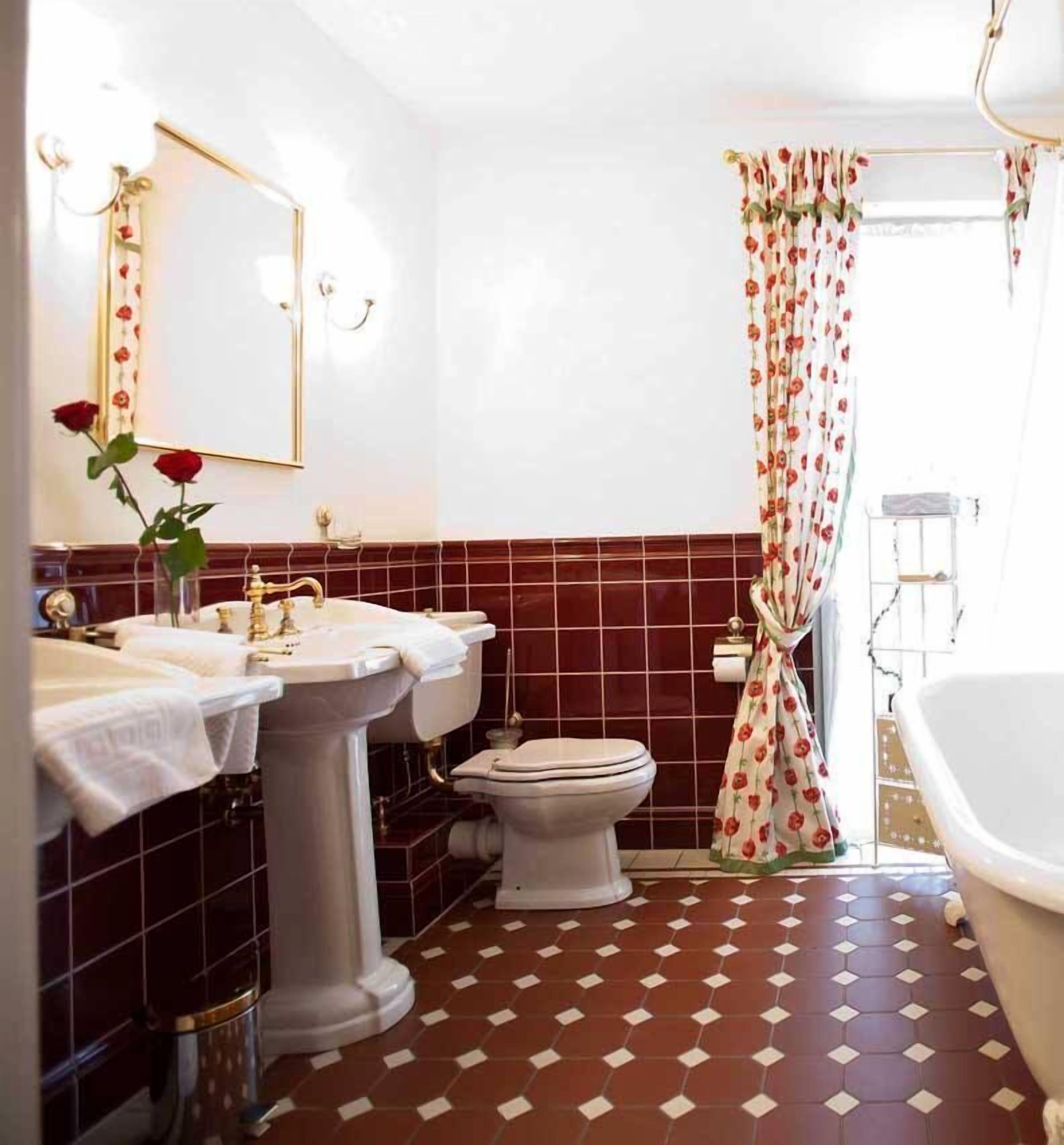 Un baño con dos lavamanos, un inodoro y una bañera.
