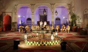 Apresentação de música tradicional num espaço com arcos e decoração elaborada.