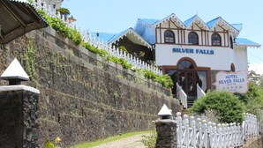 A hotel named 'Silver Falls' with a stone wall and white fence. - Hotel Silverfalls (Nuwara Eliya)