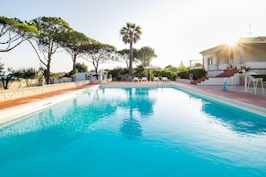 Una piscina al aire libre de temporada, sombrillas