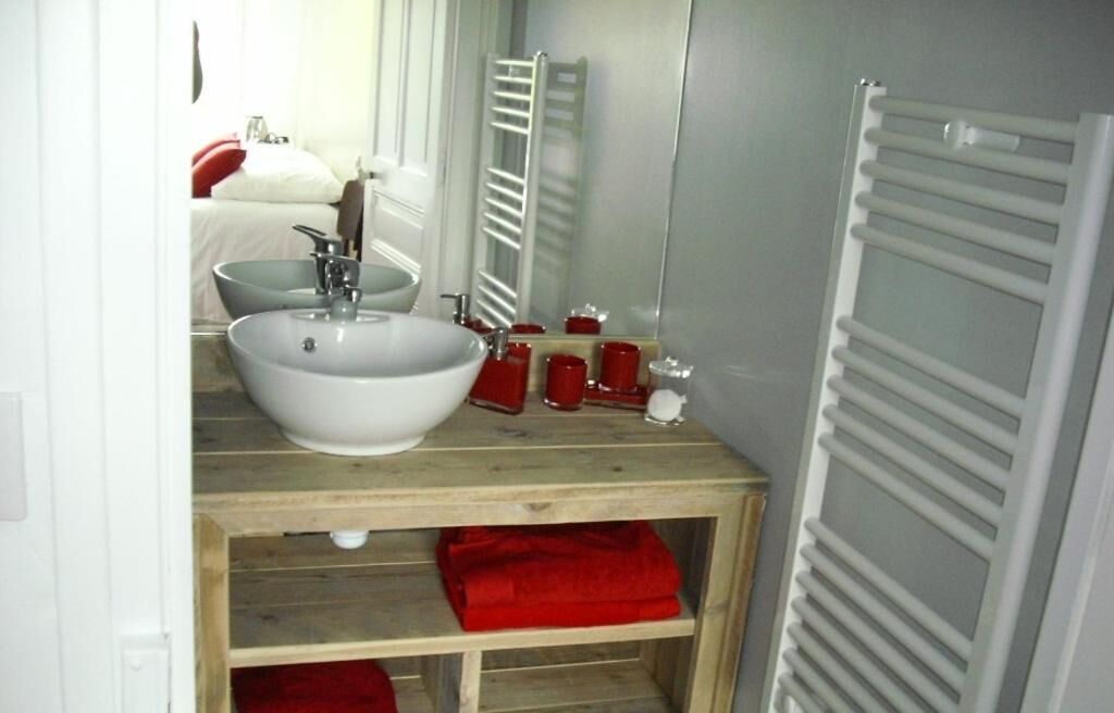 A bathroom with a white sink, a mirror, and a towel rack.