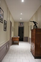 Un pasillo con una mesa de madera, un aparador y cuadros en las paredes.