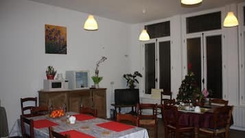 A dining area with a table set for four, a television, and a Christmas tree.