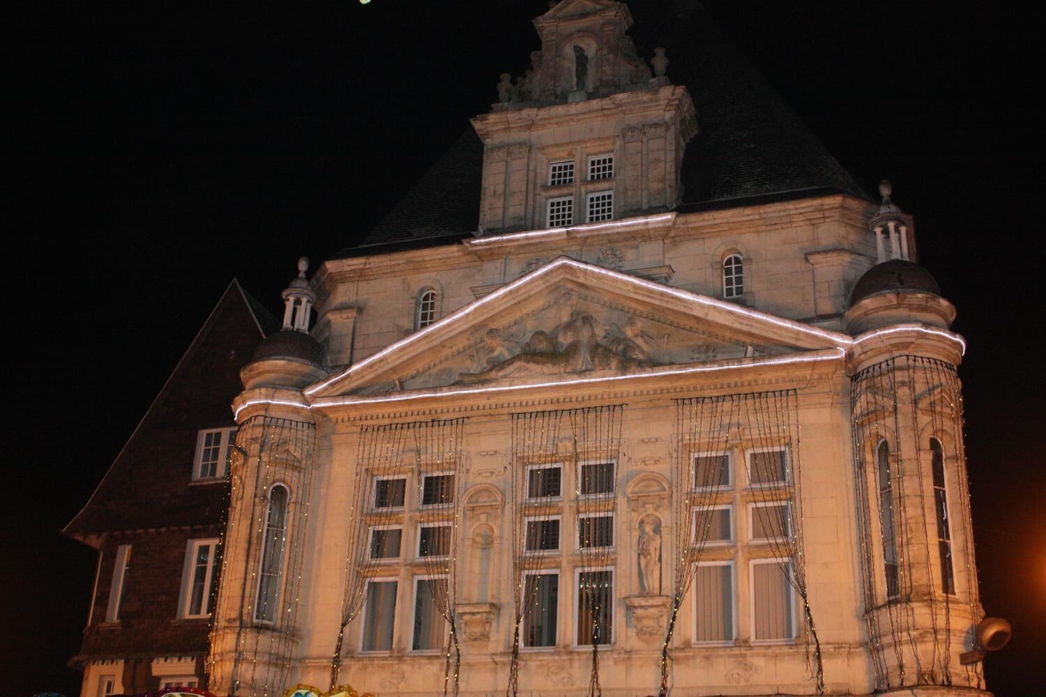 A historic building with classical architecture, featuring a prominent central pediment and symmetrical windows.