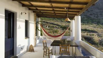 Relax in a serene outdoor seating area with a hammock, table, and chairs.