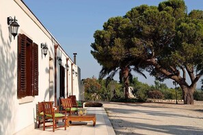 Sit and enjoy the serene surroundings from the wooden bench in front of this charming property.