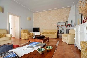 Relax in a cozy seating area with two sofas, a fireplace, and a television.