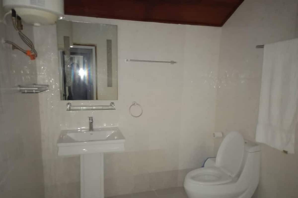 A bathroom with a white sink, mirror, and toilet.
