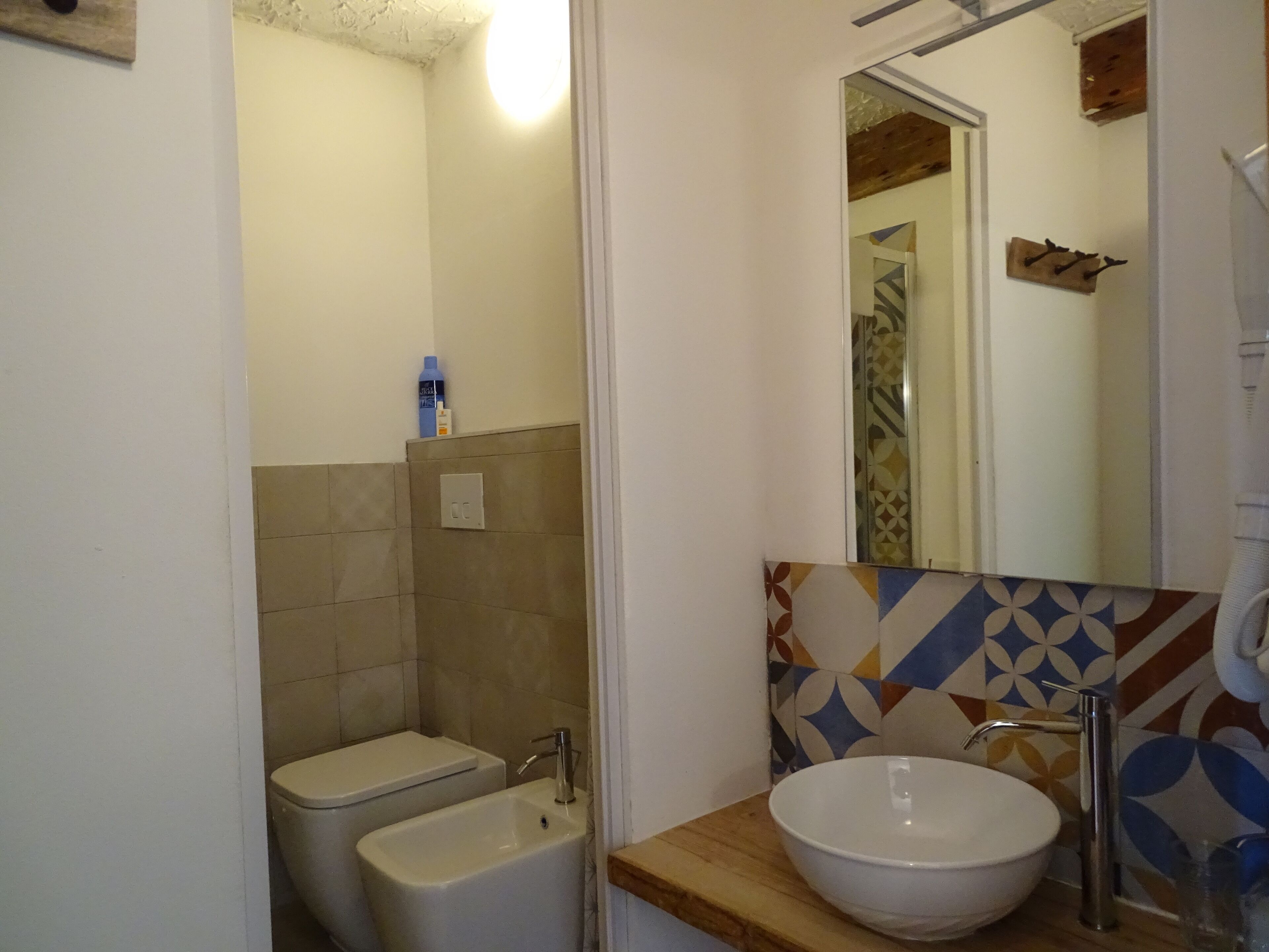 Ein Badezimmer mit Toilette, Bidet und Waschbecken mit Spiegel darüber.