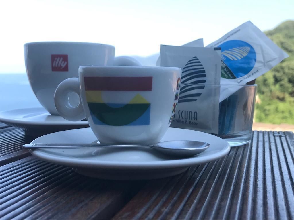 A table with a cup, saucer, and spoon.