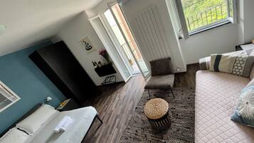 Un salon moderne avec un canapé, une table basse, un téléviseur et un balcon offrant une vue agréable.