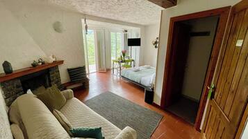 Una habitación acogedora con chimenea, un sofá, una cama y un comedor con mesa y sillas.
