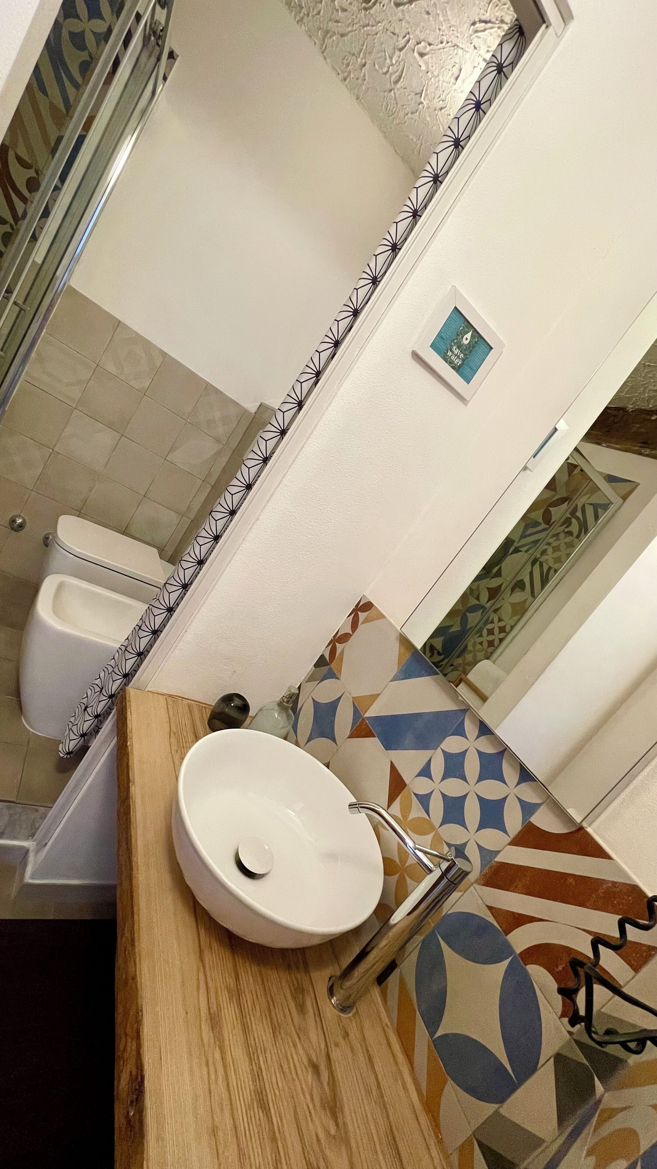 Un baño con un lavamanos blanco, un espejo y un inodoro.