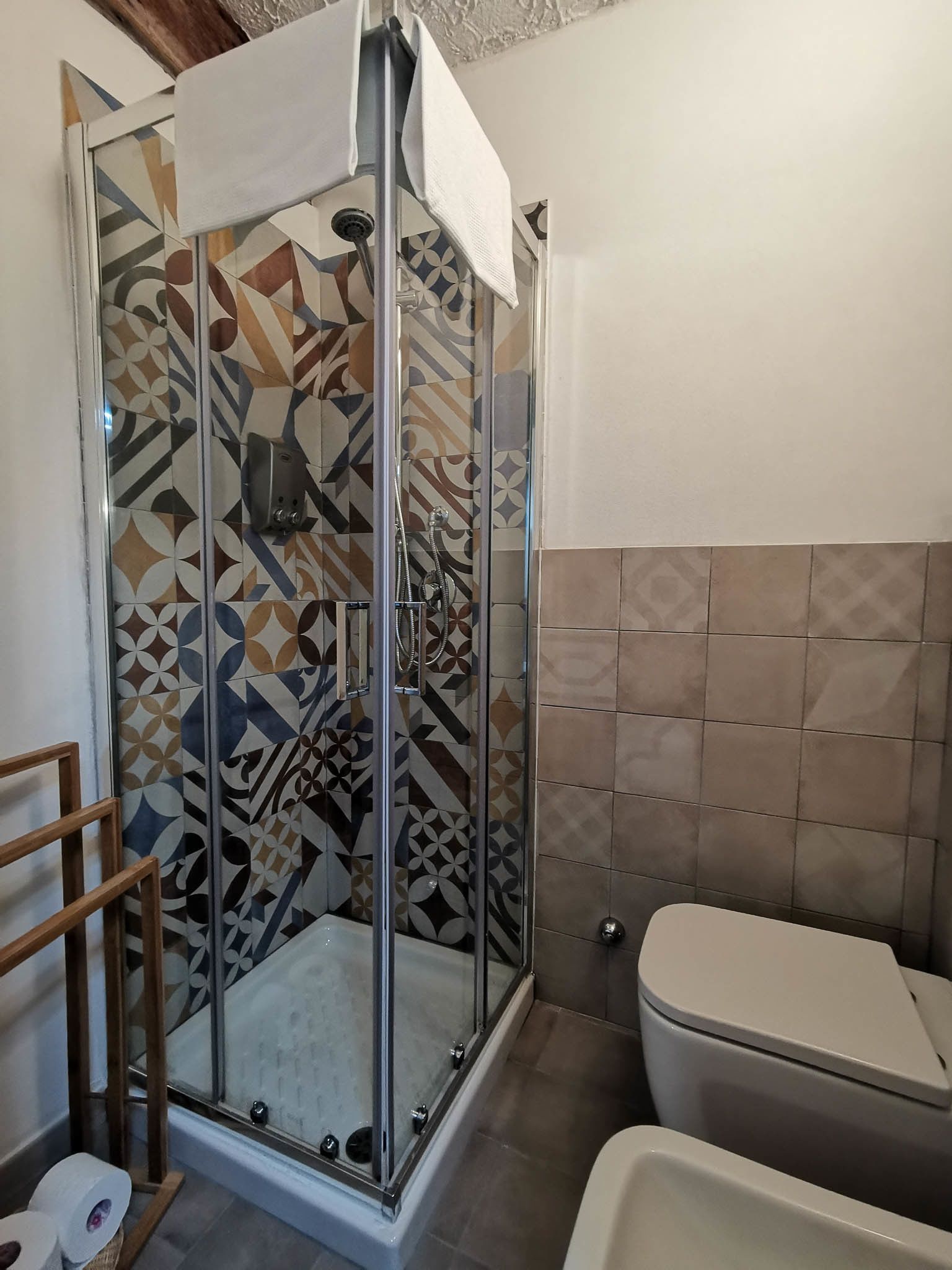Et badeværelse med brusekabine, toilet og badekar.
