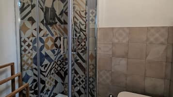 Ein Badezimmer mit Duschkabine, Toilette und Badewanne.