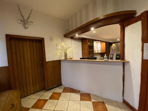 En hotellobby med en dörr av trä, en receptionsdisk och ett klinkergolv.