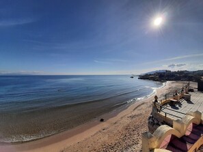 على الشاطئ، رمال بيضاء، كراسي للتشمس