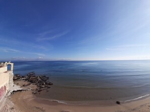 A coastal view with a clear sky, a sandy beach, and a rocky shoreline. - Silis Beach House (Spata-Artemida)