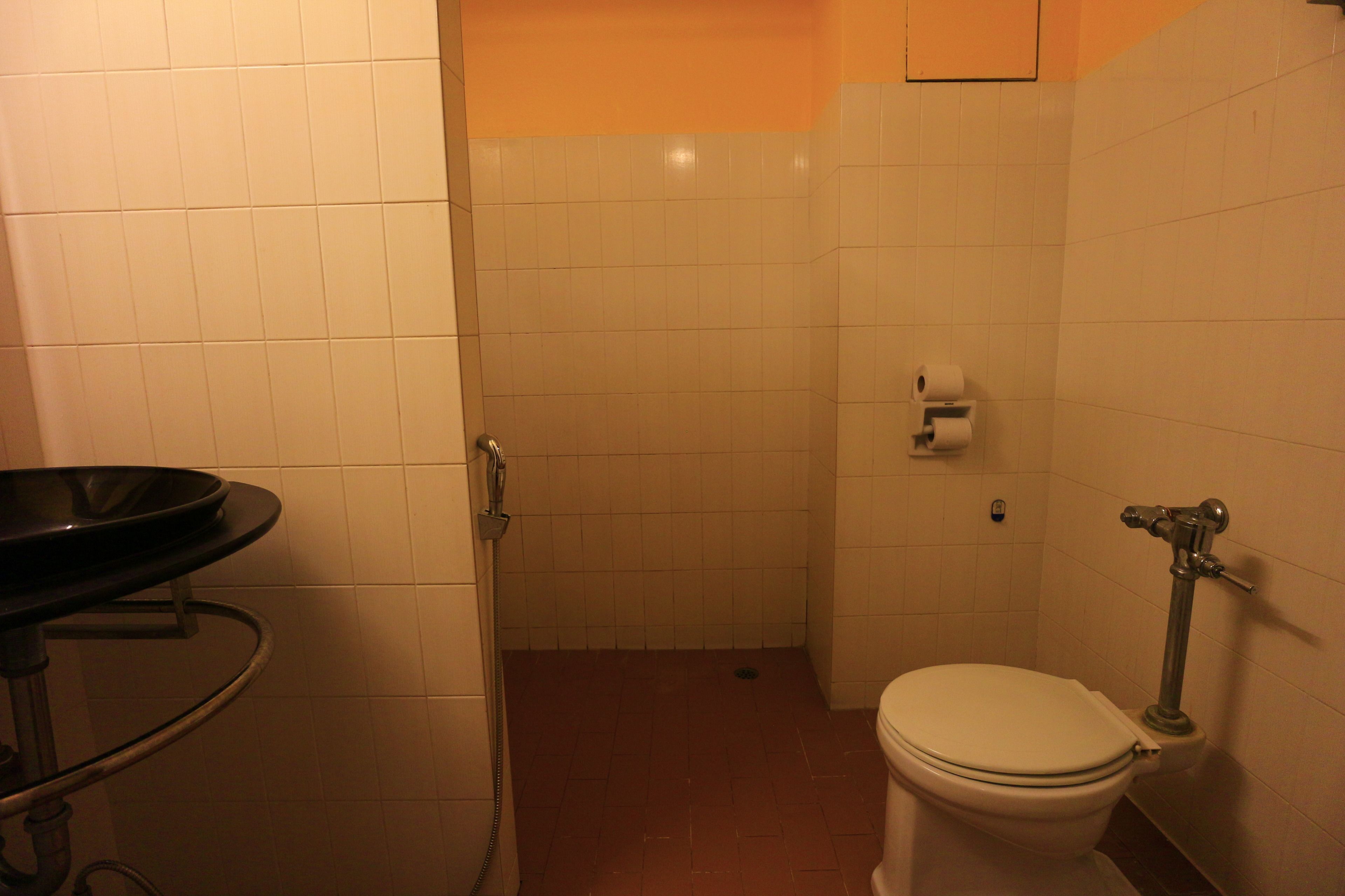 A bathroom with a toilet, a sink, and a shower stall.