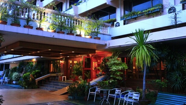 A hotel with multiple balconies, outdoor seating, and a variety of plants. - Anodard Hotel Chiang Mai (Chiang Mai)