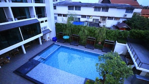 A rooftop swimming pool with a view of surrounding buildings and greenery. - Anodard Hotel Chiang Mai (Chiang Mai)