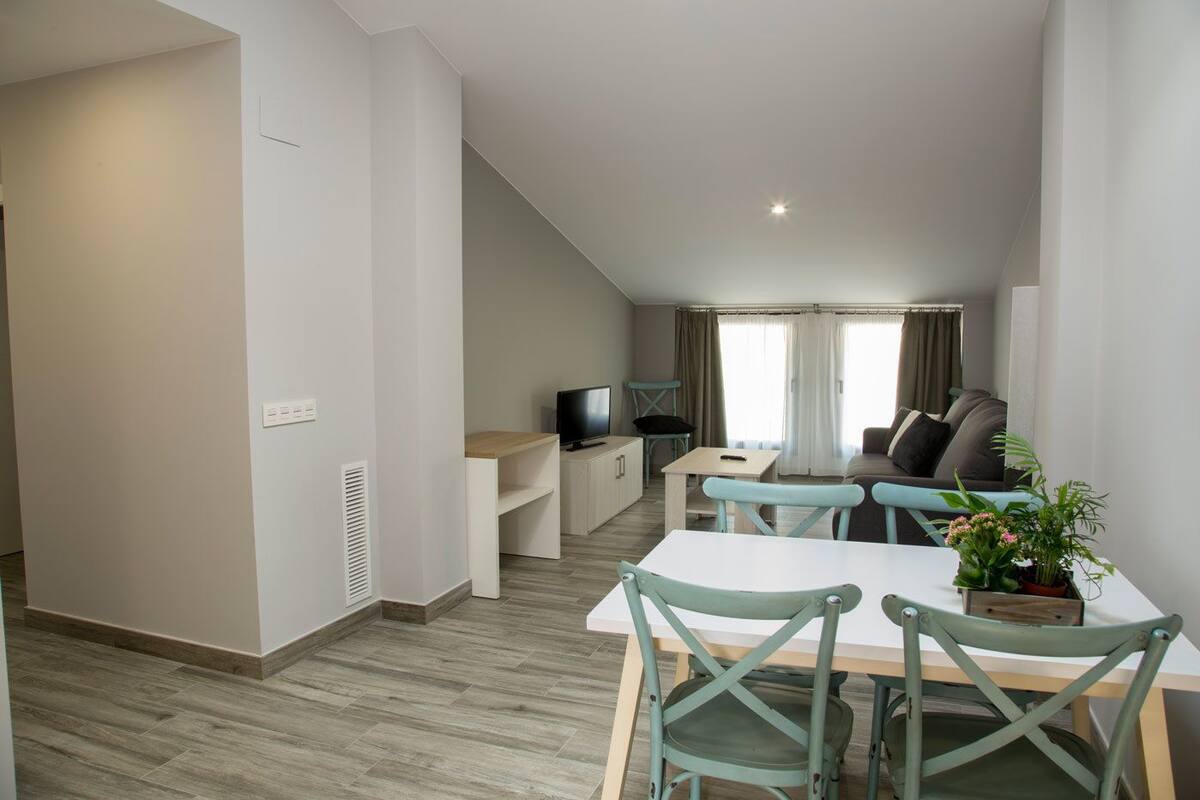 Un appartement moderne comprenant un coin repas, un salon et une kitchenette.