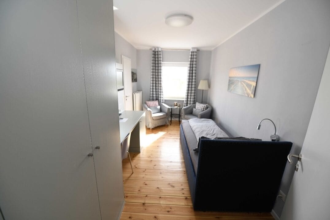 A compact room with a bed, a desk, and a chair.