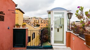 A narrow alleyway with a glass door entrance leading to a small, enclosed space with a curved roof. - Residenza Del Cedro (Rome)
