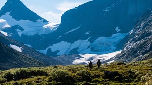 Un paisaje montañoso con dos excursionistas.