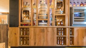 A wooden bar area with various bottles and glasses, including a large barrel labeled 'Scheitel'. - Landgasthof Rebstock (Ottenhofen im Schwarzwald)