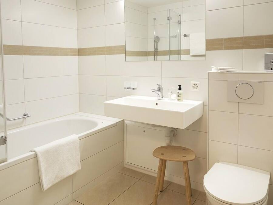 Een moderne badkamer met een bad, wastafel en toilet.