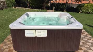 A hot tub with two warning signs on its side.
