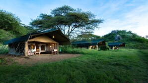 A safari lodge with tents and a dining area.