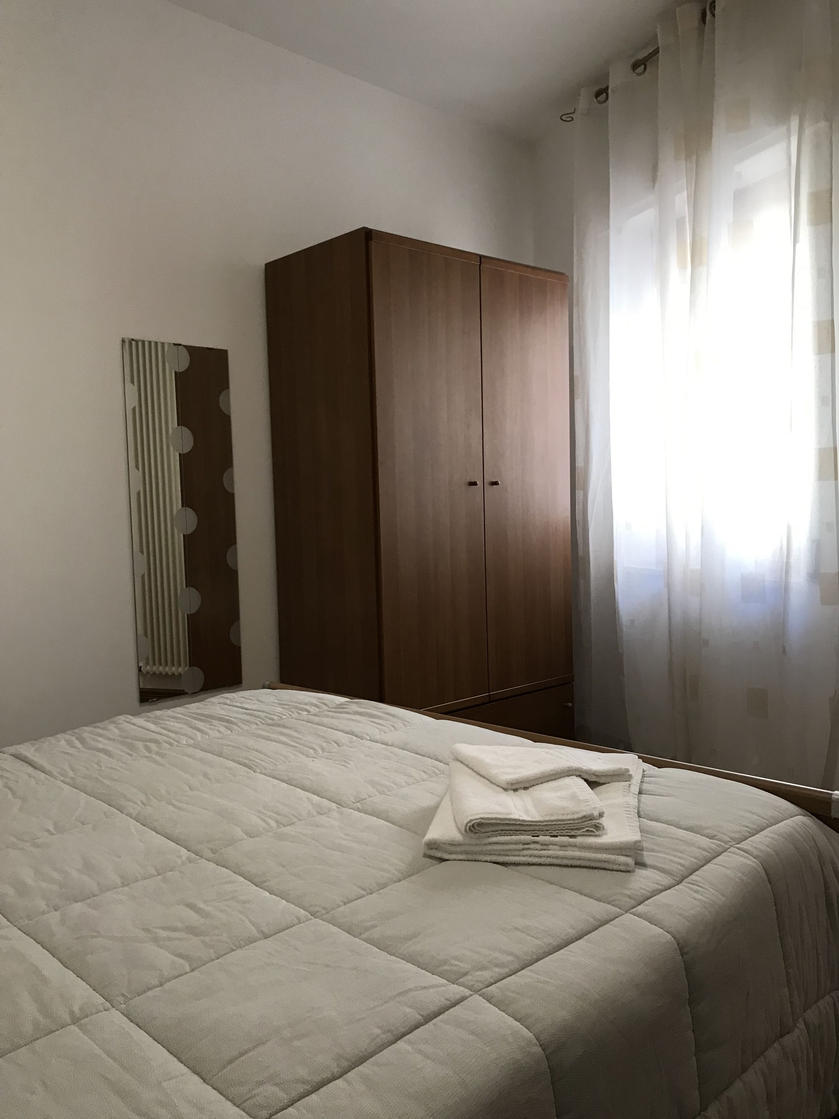 Ein Schlafzimmer mit einem Bett, einem Kleiderschrank und einer Heizung.
