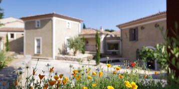 Un barrio residencial con casas de estilo arquitectónico uniforme, un camino y diversas flores en primer plano.