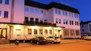 A hotel with a sign reading "Bryggen Hotel," featuring a modern facade, multiple windows, and a balcony on the upper floor. - Nordfjord Hotell - Bryggen (Stad)