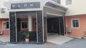 La entrada de un edificio con el letrero "GLMH" sobre un área de acceso cubierta.