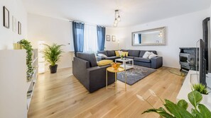 A modern living room with a grey sofa, a coffee table, and a fireplace. - Superior Stay Zagreb (Zagreb)
