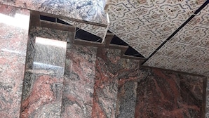 A marble staircase with a wooden handrail, leading to a patterned ceiling. - Pensión Martín (Jaén)