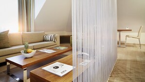 A modern living room with a sofa, coffee table, and a decorative partition. - Das Spritzenhaus (Eltville am Rhein)
