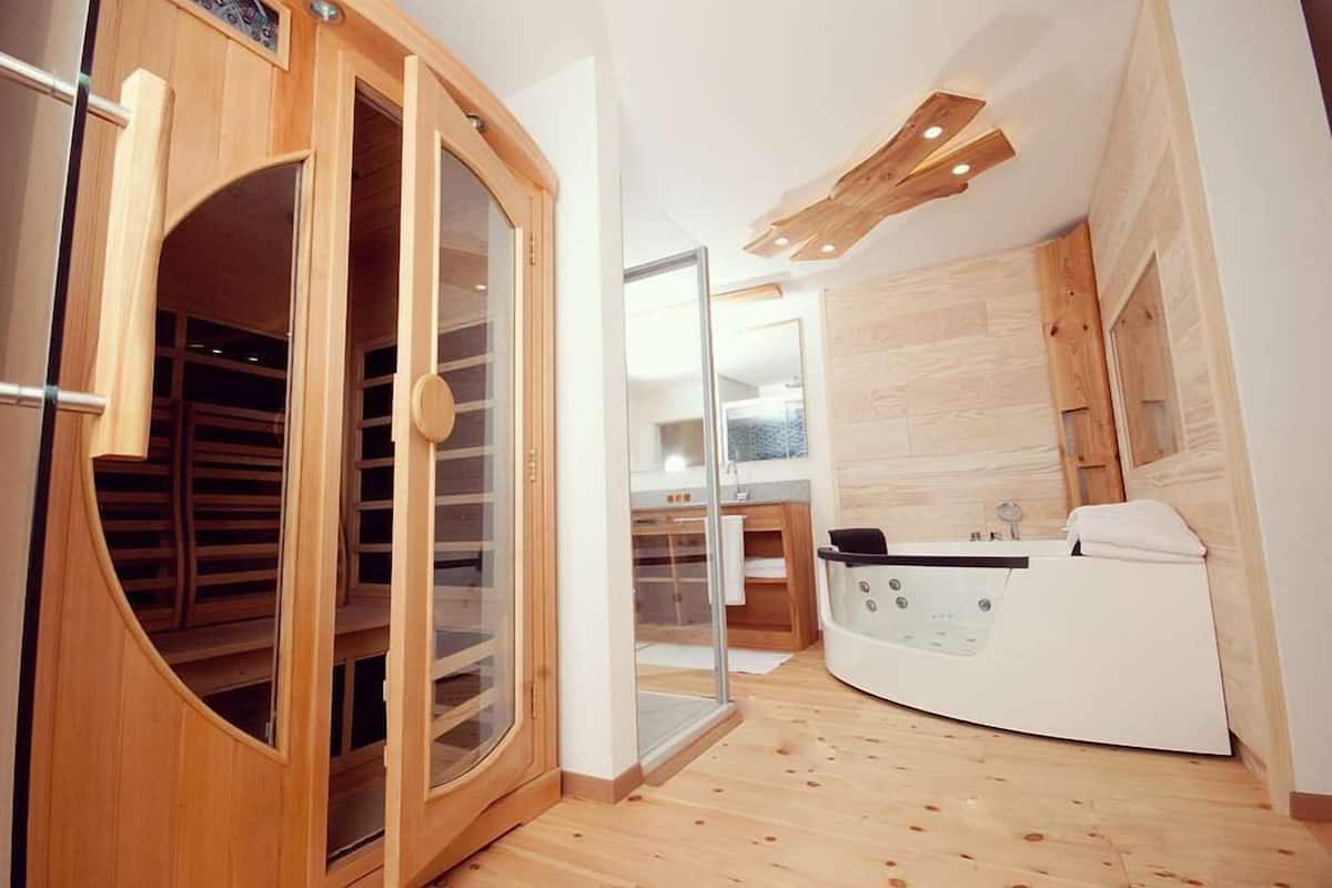 A modern bathroom with a freestanding bathtub, a glass shower enclosure, and wooden cabinetry.