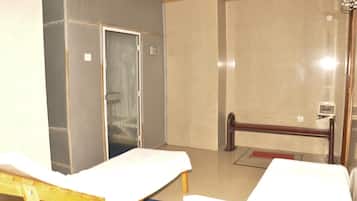 Cozy retreat with a single bed, wooden bench, and glass door leading to another area.