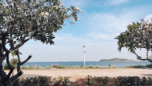 Una platja amb una vista clara del mar i un perfil urbà llunyà.