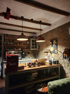 A room with a wooden table, a motorcycle, and a laptop.