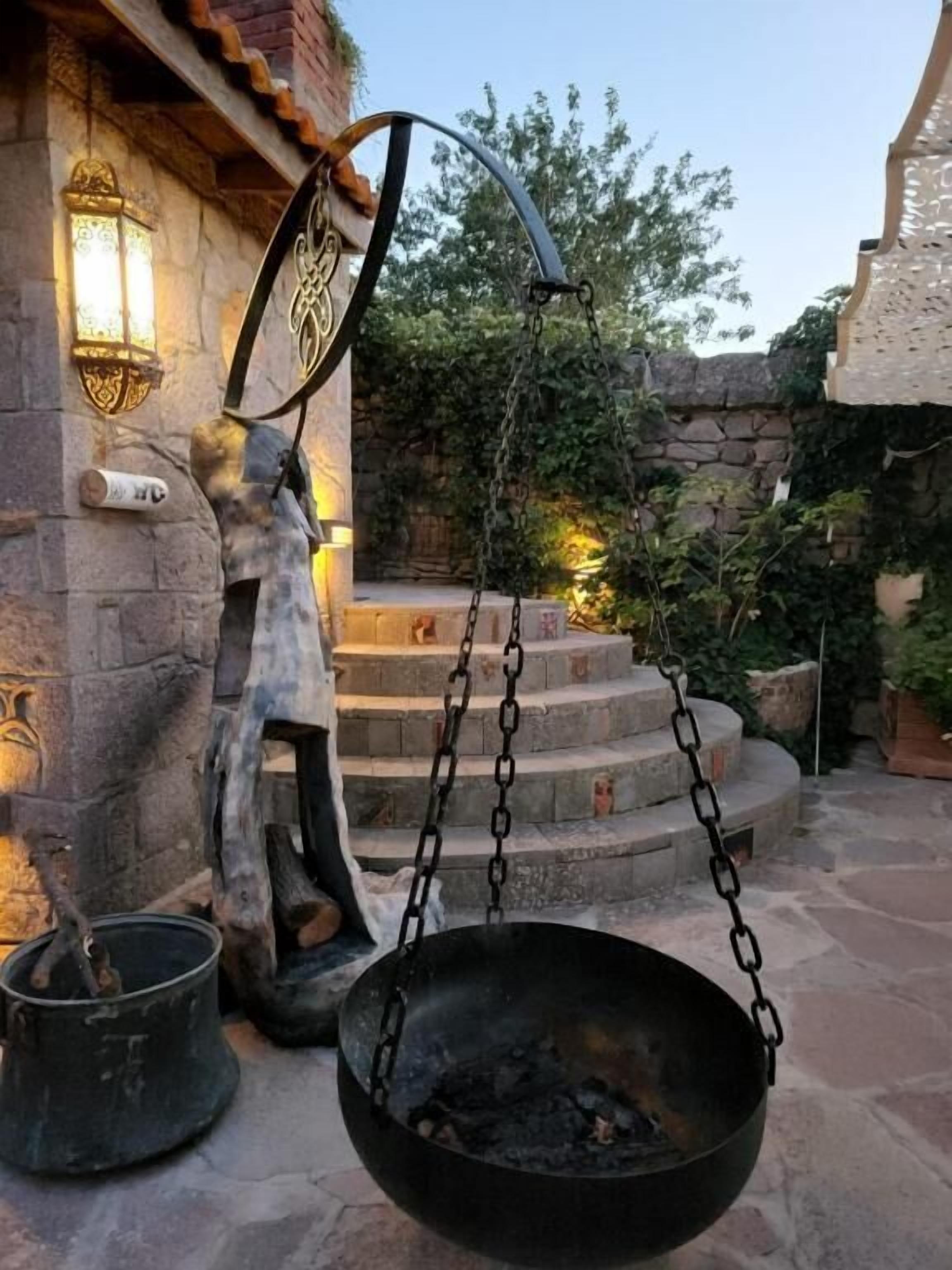 A stone building with a hanging pot and a lantern.
