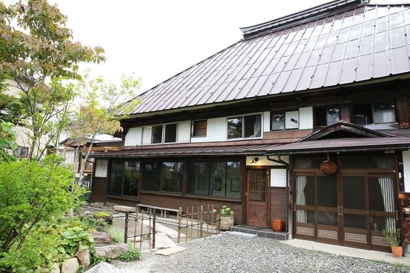 A traditional Japanese building with a tiled roof, large windows, and a wooden entrance. - Hakuba Youluri (Hakuba)