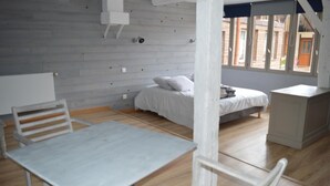 Een kamer met een bed, een tafeltje en een stoel.