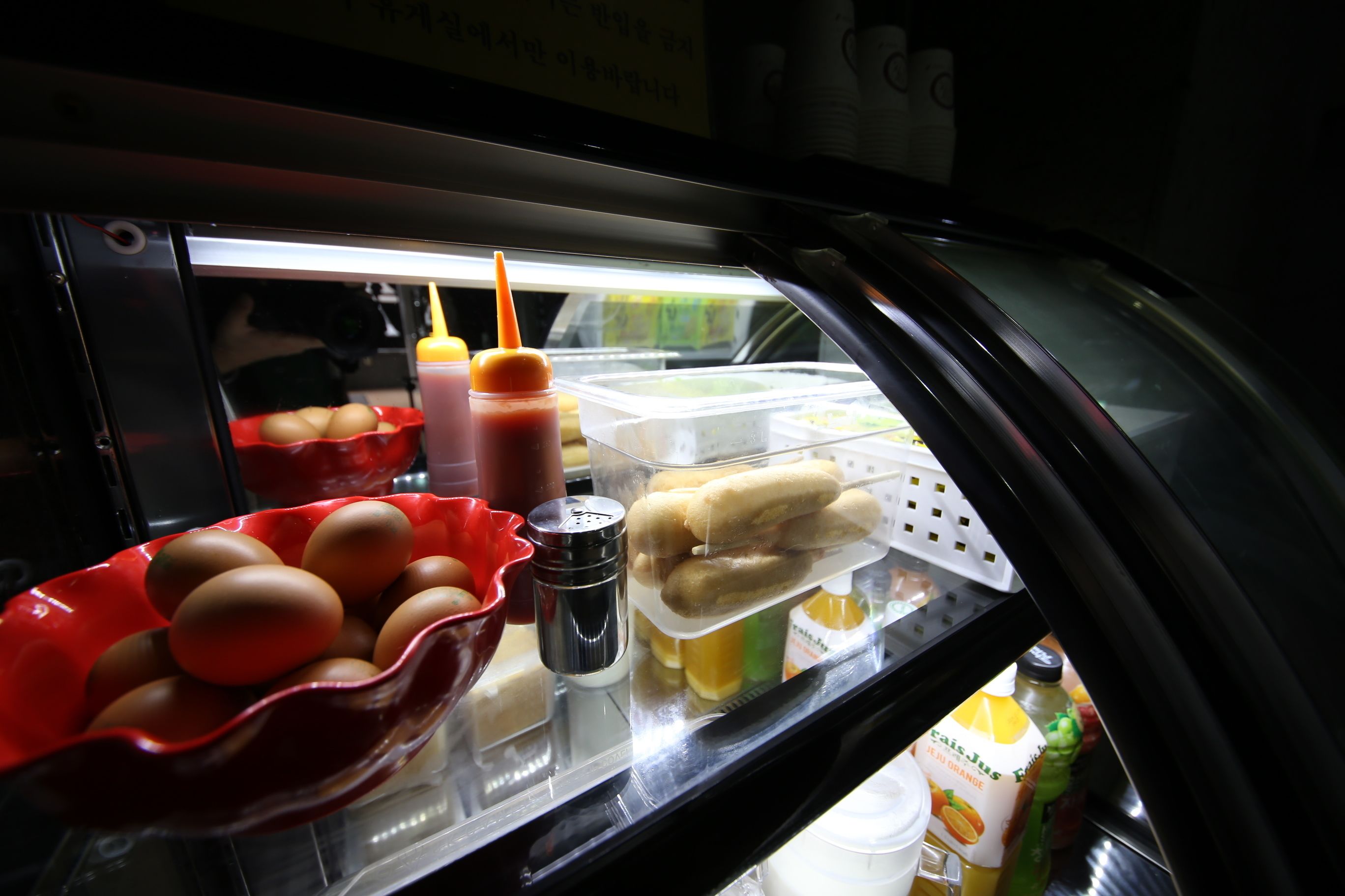 A refrigerator stocked with eggs, condiments, and beverages.