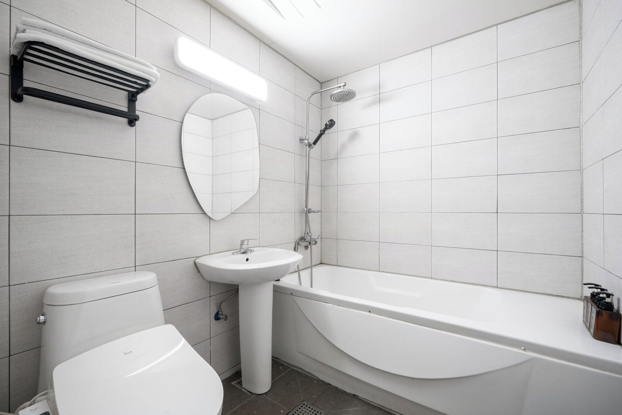Une salle de bain moderne équipée de toilettes, d’un lavabo et d’une baignoire.